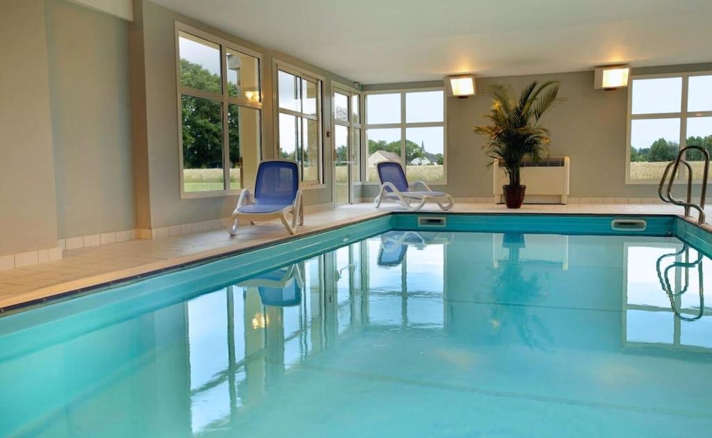 Beaune Levernois - Piscine Chauffée, Sauna et Golf في ليفيرنوا: مسبح مع كرسيين ازرق في مبنى