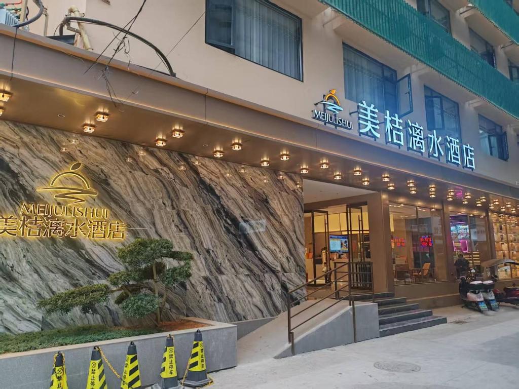 Un edificio con un cartel al costado. en Guilin Meiju Lishui Hotel, en Yangshuo
