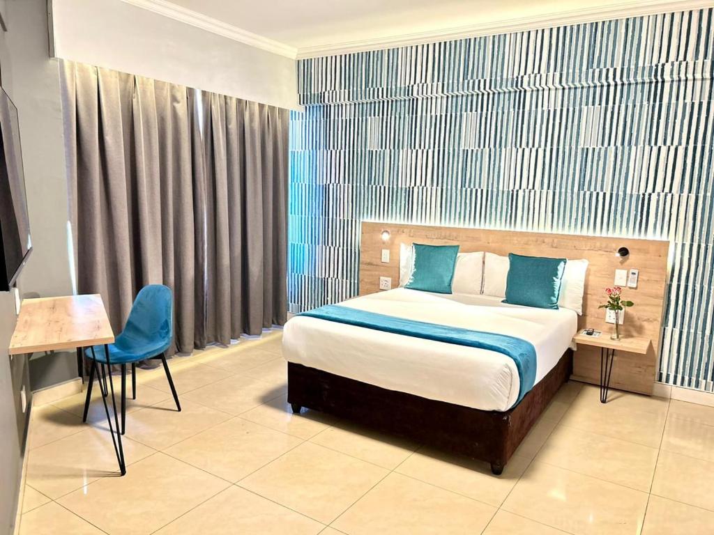 a hotel room with a bed and a table and a chair at Bayside Self Catering and Hotel 14 Monty Naicker Pinestreet Durban in Durban