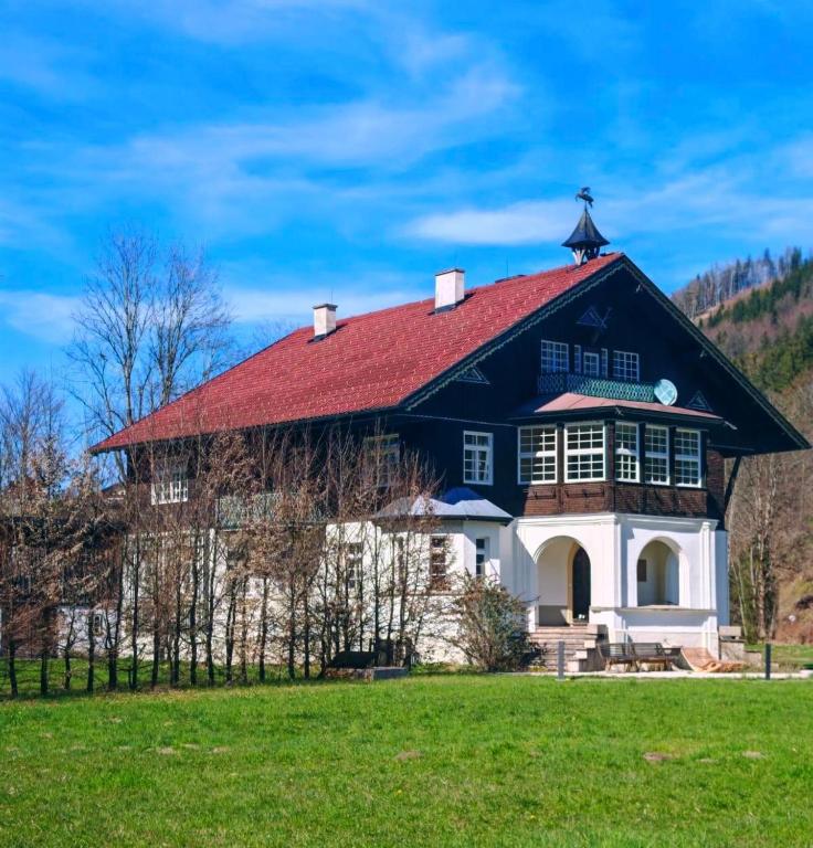 a large black and white house with a red roof at Forsthaus Faistenau in Hintersee