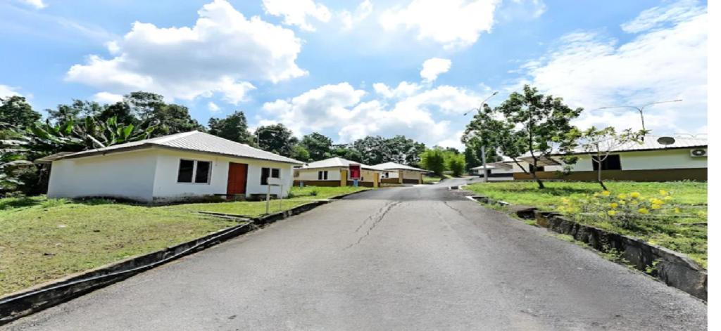 HP Usima Forest Resort Melaka في آير كيروه: طريق فارغ في قرية فيها بيوت