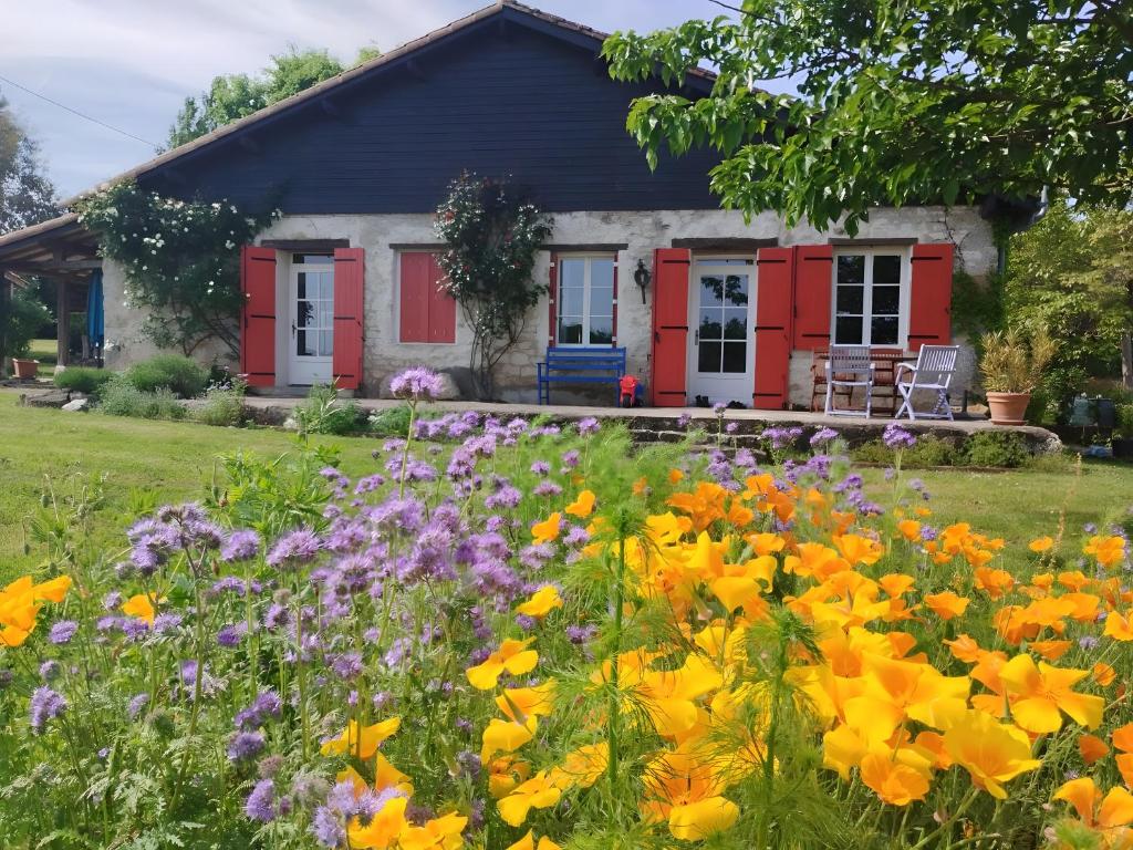een tuin met bloemen voor een huis bij Gite Laurélie, Un Écrin De Sérénité in Trémons