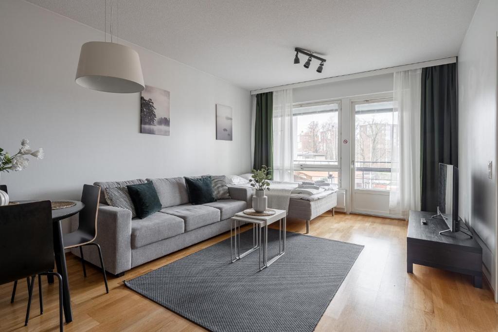 ein Wohnzimmer mit Sofa und Tisch in der Unterkunft "ESPA" - Modern 1BR Apartment with Sauna, Balcony & Free Parking in Tampere