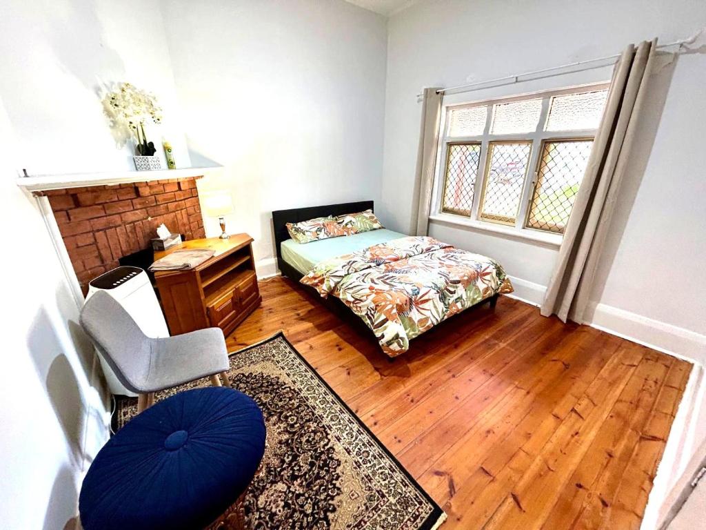 Un dormitorio con una cama y un escritorio y una ventana. en 3BR Guest House near Adelaide CBD Joslin 5070, en Evandale