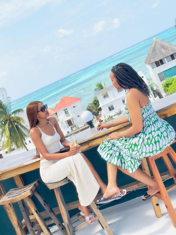 two women sitting at a bar on the beach at Leparadis Zanzibar Boutique Hotel in Jambiani