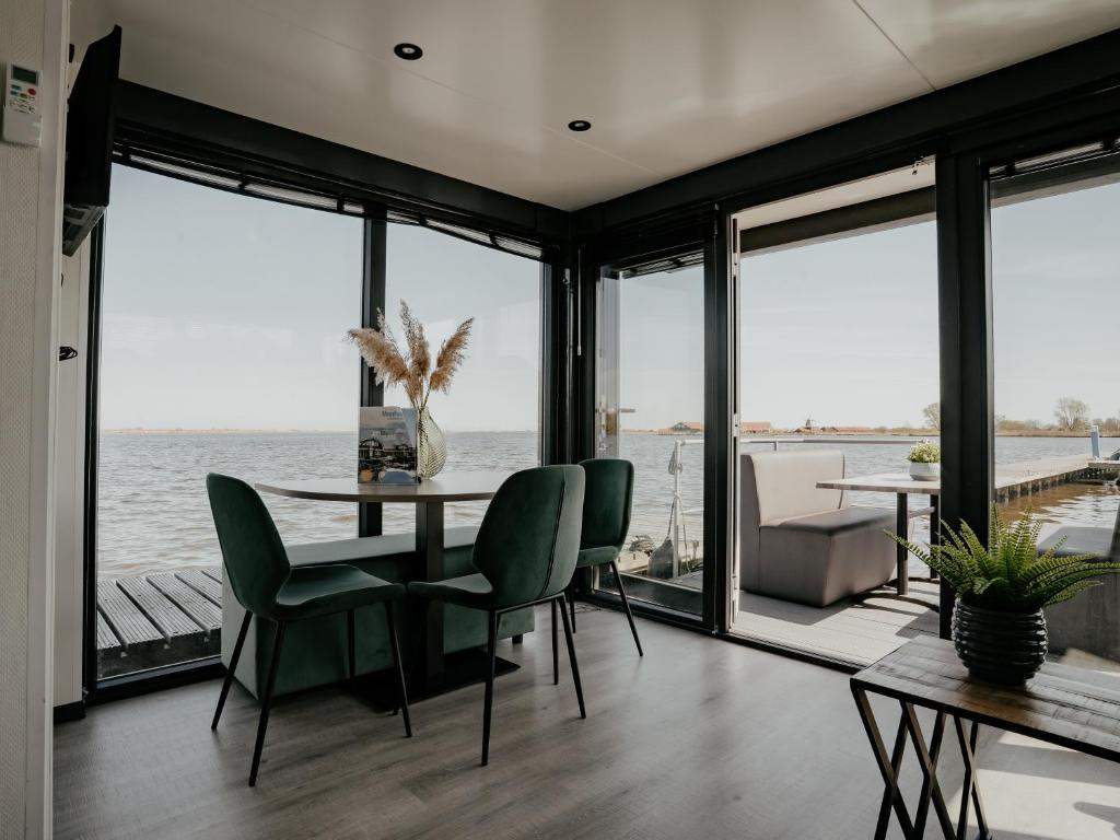 a dining room with a view of the water at Houseboat Uitgeest with Air Conditioning | 4 people in Uitgeest