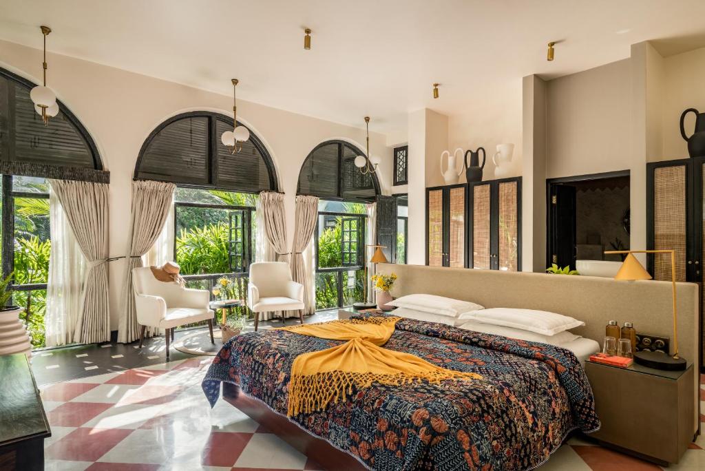 1 dormitorio con 1 cama grande y algunas ventanas en Viraam by RÊVE Escapes, en Assagao