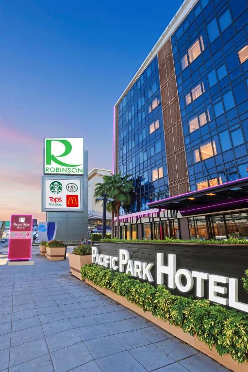 a park hotel sign in front of a building at Pacific Park Hotel in Si Racha