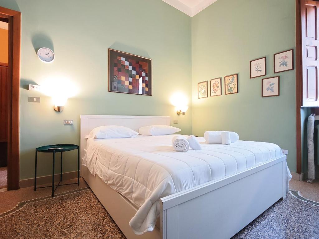 a bedroom with a large bed with white sheets at Dimora Cavour in Monopoli