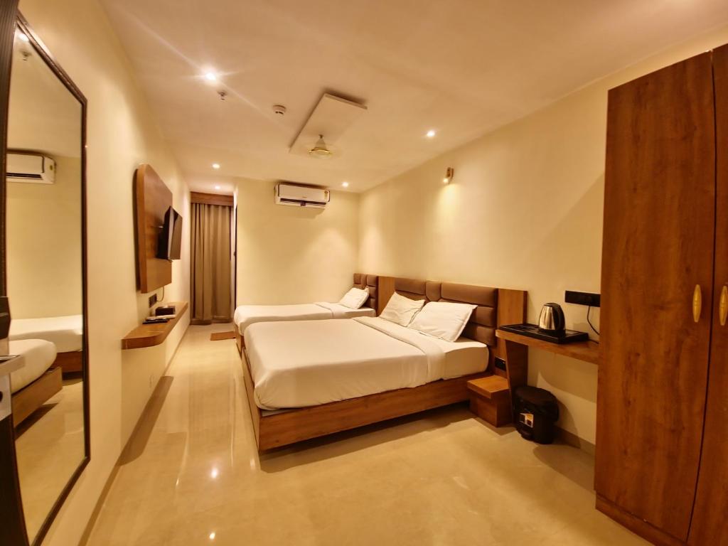 een hotelkamer met een bed en een badkamer bij Hotel Lancaster in Mumbai