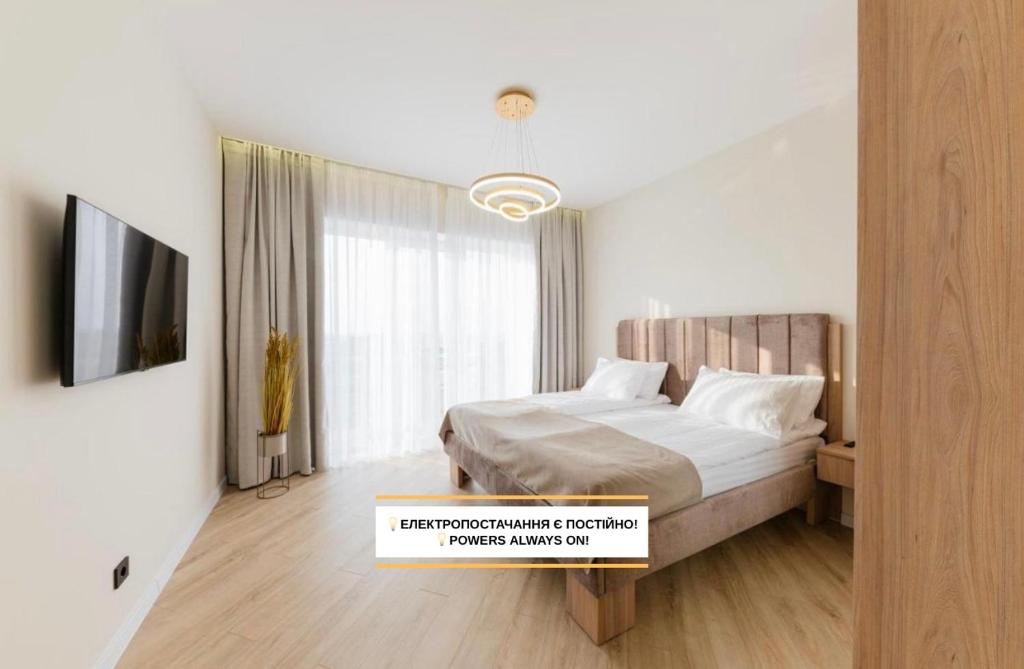 ein Schlafzimmer mit einem Bett und einem Fernseher in der Unterkunft MM GROUP APARTMENT GOLD in Uschhorod