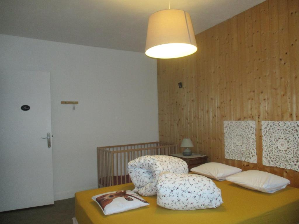 Una habitación con una silla sobre una mesa. en La Source - appart 85 m2 & terrasse privée rdc, en Orcival