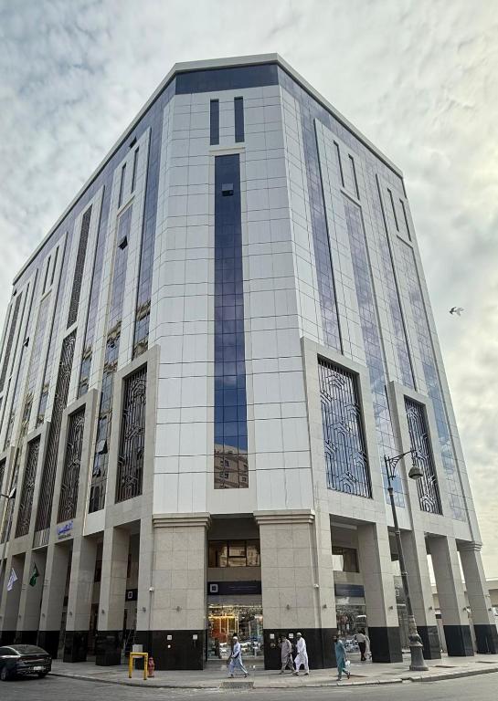 a large building with people walking in front of it at Ancyra Hotel - By Continent - فندق انكيرا in Medina