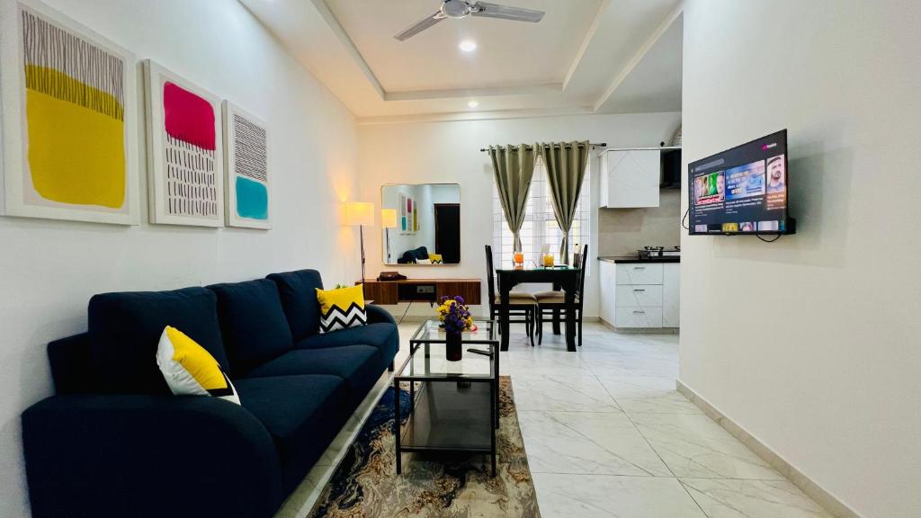 a living room with a blue couch and a table at Olive Service Apartments BTM Layout in Bangalore