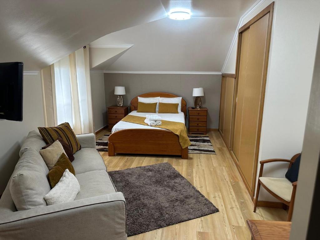 un soggiorno con un letto e un divano di Moniz Apartment a Caniço