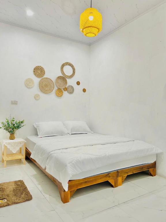 a white bedroom with a large bed in a room at The Mountain Homestay & Cafe in Văn Lâm