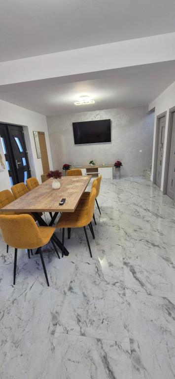 a dining room with a wooden table and chairs at Casa Maxi in Gherla