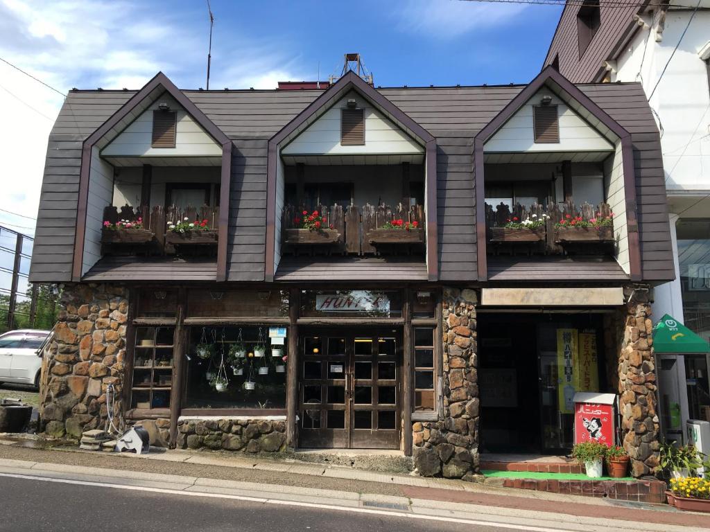 een gebouw met bloembakken op de ramen bij Hunter Lodge in Myoko