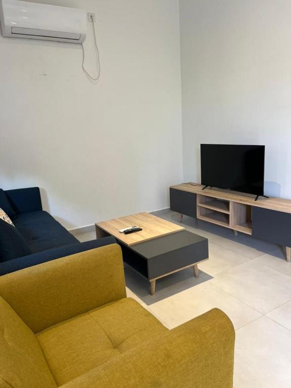 a living room with a couch and a tv at Résidence Guebbas in Skikda