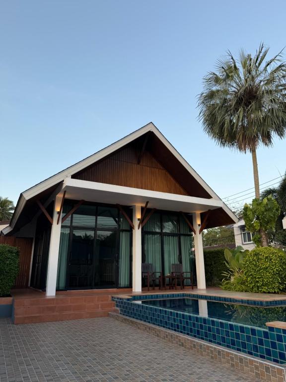 ein Haus mit einem Wintergarten mit einer Palme in der Unterkunft Pool villa Aonang 2 room 2 bedroom in Ao Nang Beach