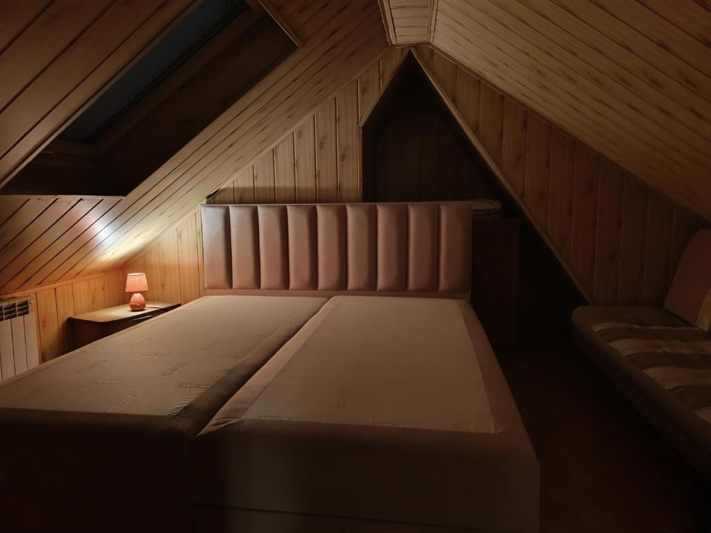 un letto in soffitta con una lampada su un tavolo di Apartamenty pod Jesionami u Bartka a Zakopane