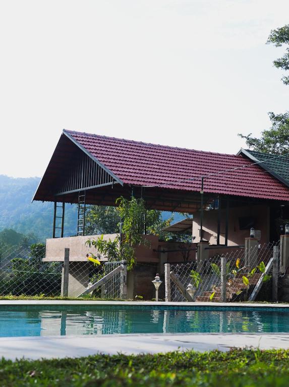 a building with a swimming pool in front of it at The Rain Tree resort in Kutta