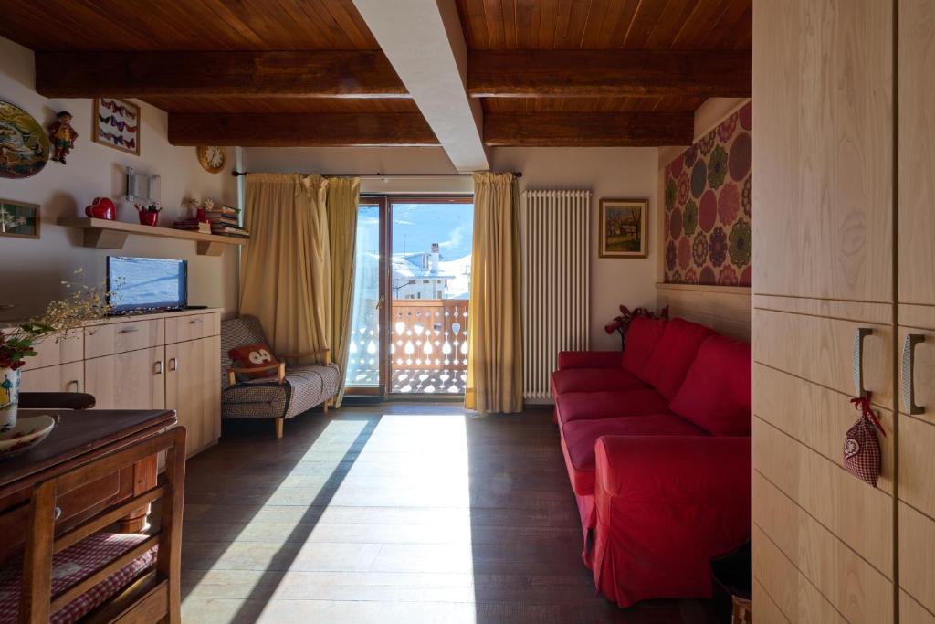 a living room with a red couch and a balcony at Mono 1400 in Limone Piemonte