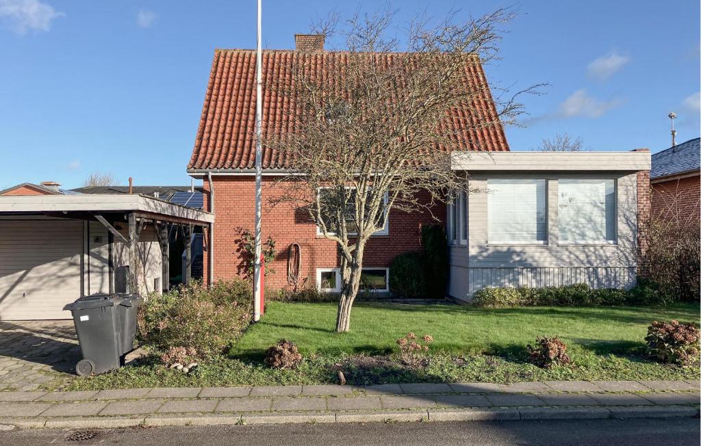 3 Bedroom Cozy Home In Bøvlingbjerg في Bøvlingbjerg: منزل به شجرة في الفناء الأمامي
