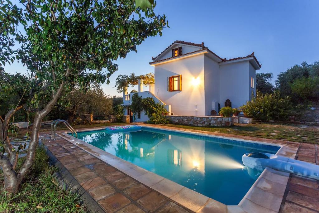 a villa with a swimming pool in front of a house at Μeropi & Natalia Villas in Skopelos Town