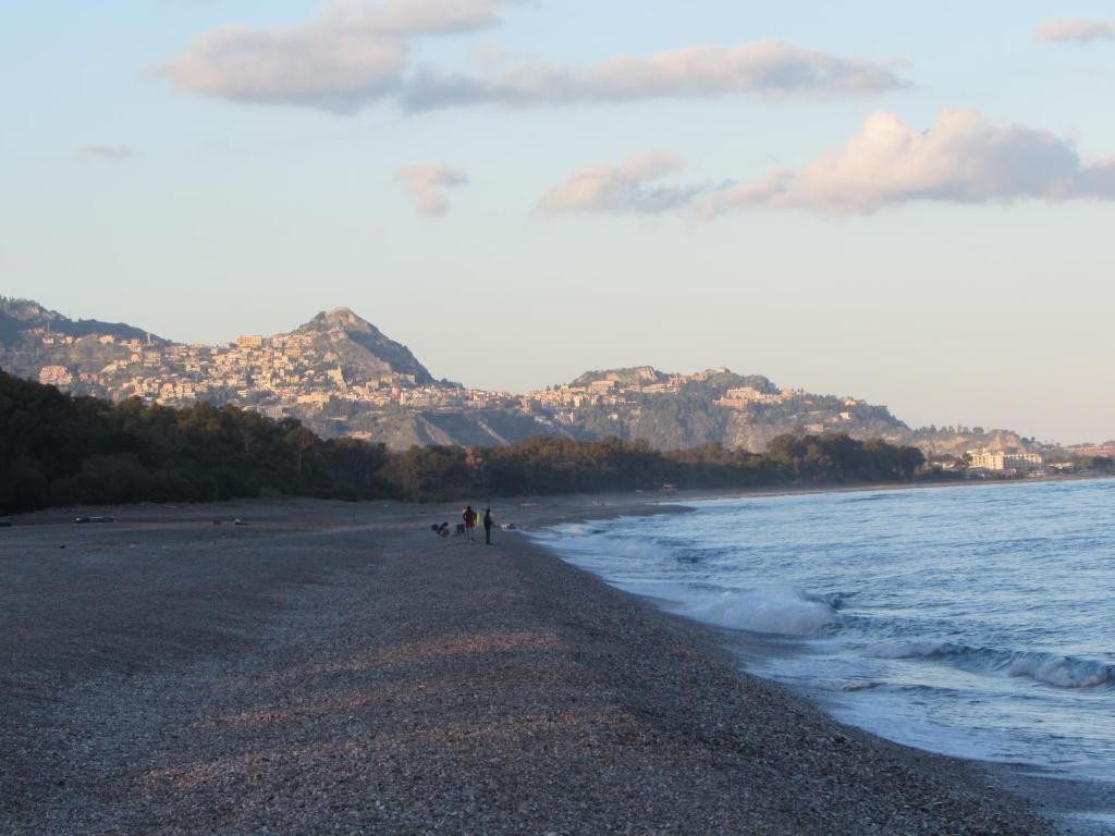 a group of people walking on the beach at Sicily Etna Mareneve Taormina in Fiumefreddo di Sicilia