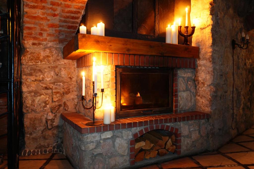 a stone fireplace with candles in a room at Witch House Apartment in Rīga