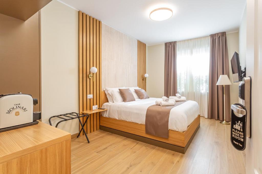 a hotel room with a bed and a television at Guest House Aura - Lumys Fiumicino in Fiumicino