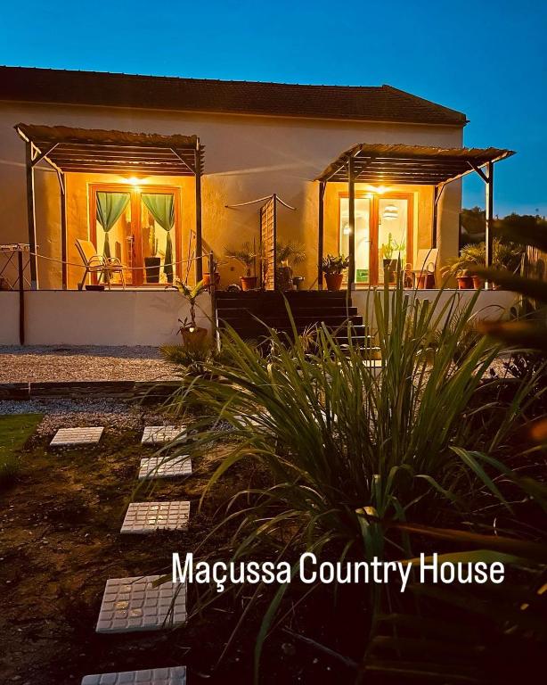 a house with lights on the front of it at Maçussa Country House in Massuça
