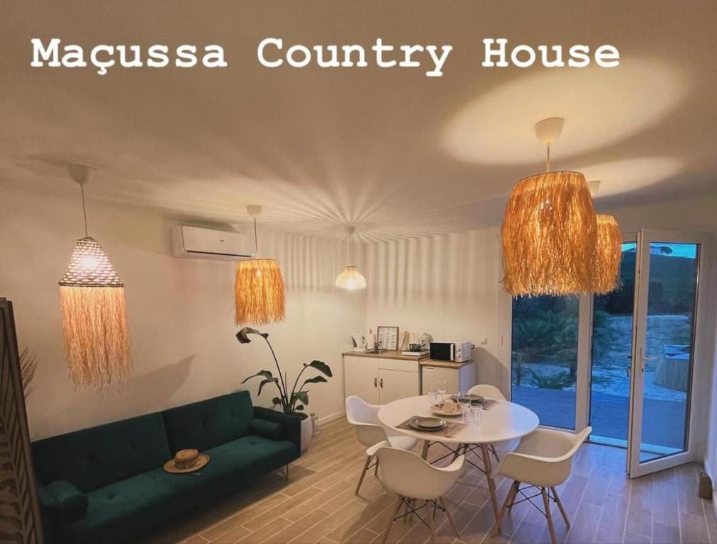 ein Wohnzimmer mit einer grünen Couch und einem Tisch in der Unterkunft Maçussa Country House in Massuça