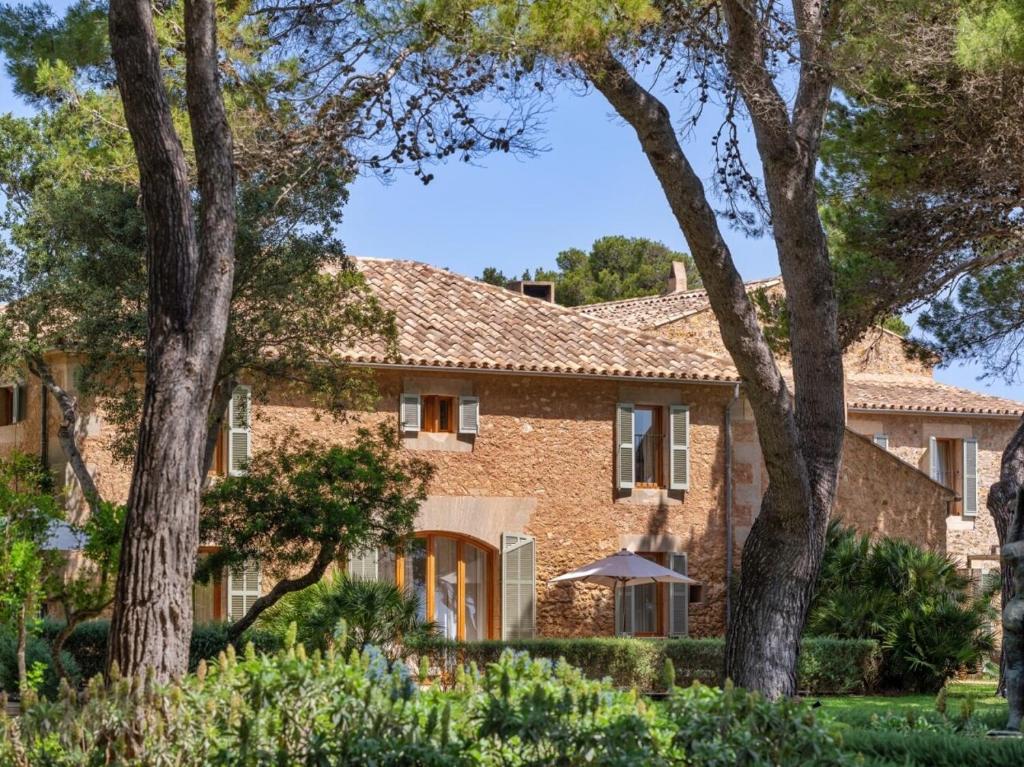 a brick house with trees in front of it at Can Simoneta - Adults Only in Canyamel