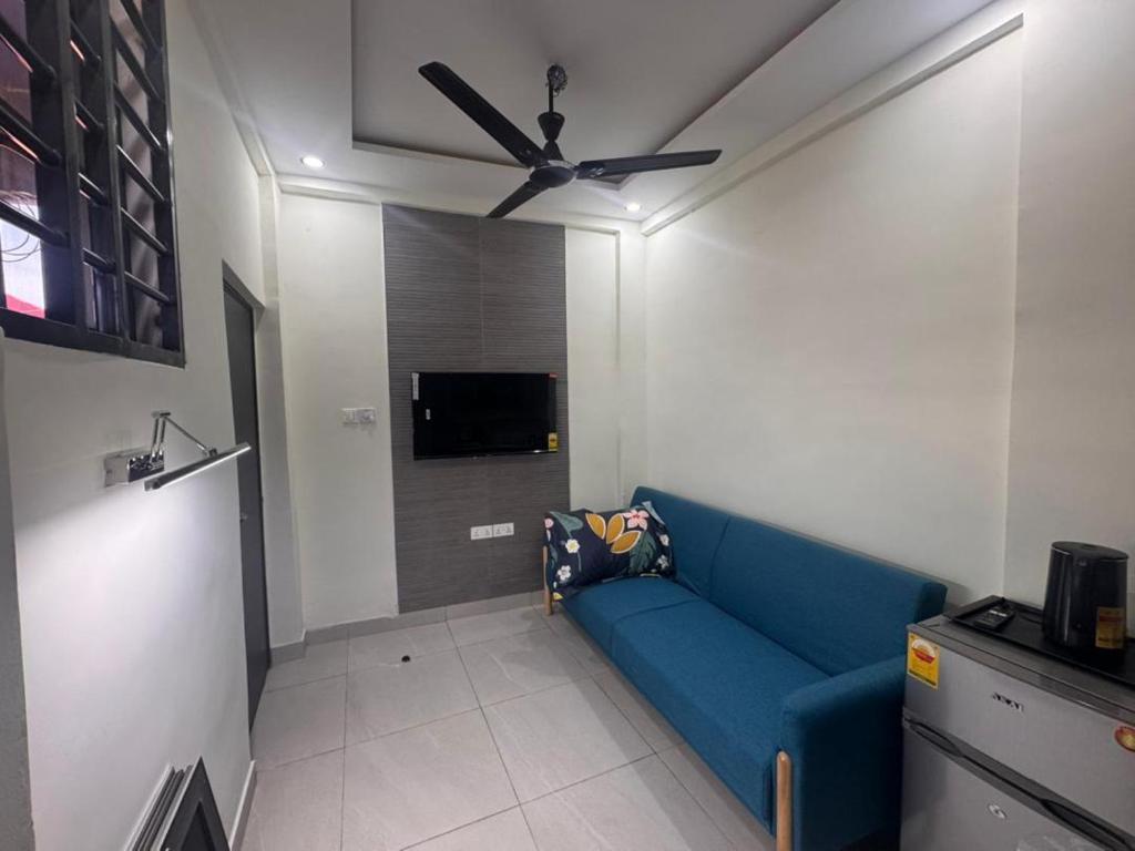 a living room with a blue couch and a ceiling fan at La Villa Petite in Lapaz