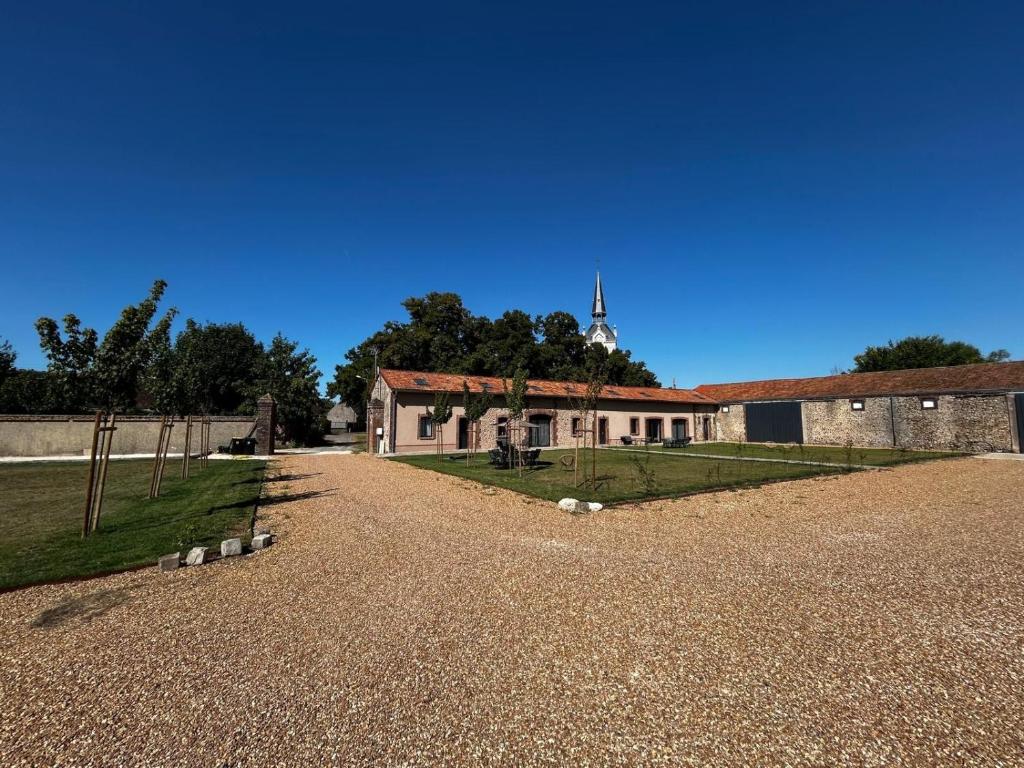ein altes Gebäude mit einem Turm im Hintergrund in der Unterkunft Les Gîtes du Colombier in Ollé
