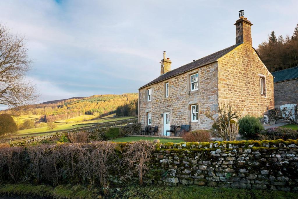 an old stone house with a stone wall at Wharfe View Cottage Bolton Abbey Estate in Skipton