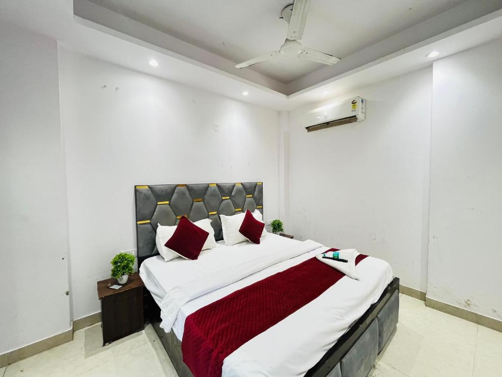 Un dormitorio con una cama grande con almohadas rojas. en Hotel 24 Stay - Near Max Hospital, en Nueva Delhi