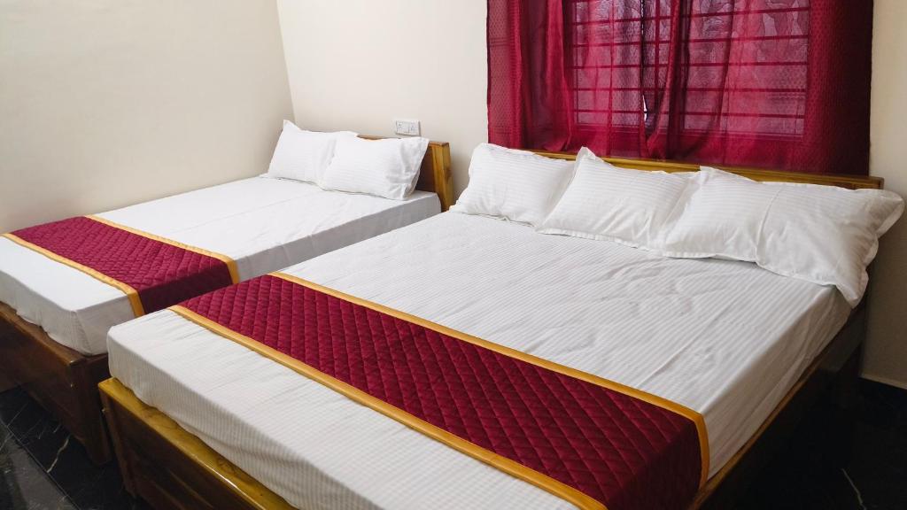 Seetha Residency في تيروفانمالي: سريرين في غرفة مع نافذة حمراء