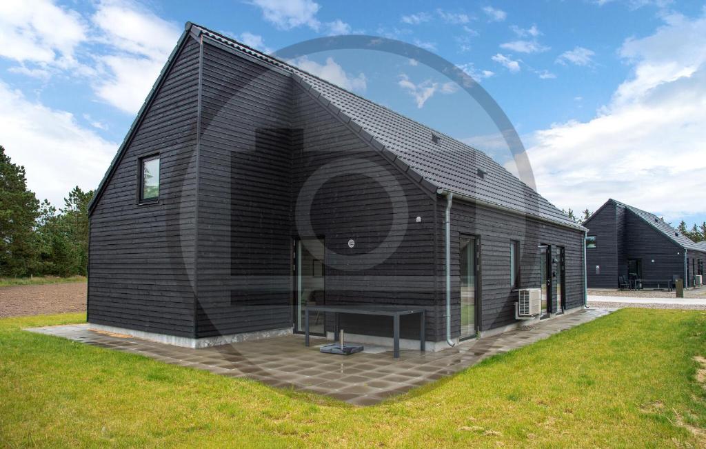 een zwart huis met een zwart dak bij Amazing Home In Haderslev in Diernæs