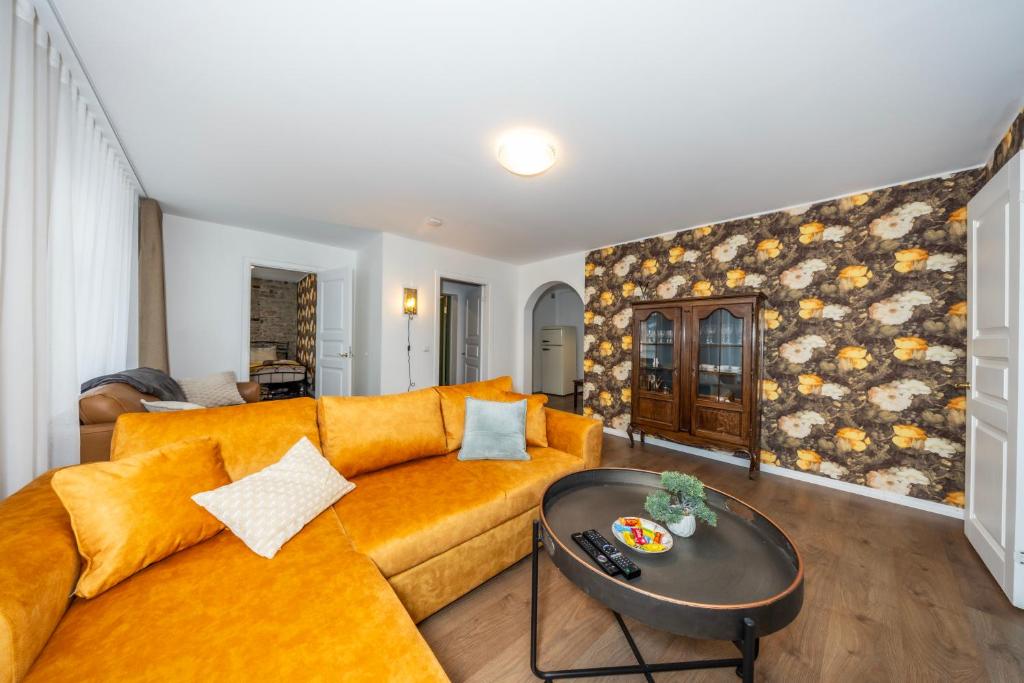 a living room with a yellow couch and a table at Old Town Luxury 2 Bedroom Suite 65 m2 on 3rd floor in Tallinn