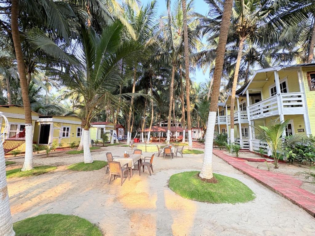 a patio with tables and chairs in front of a building at Samant Beach Resort in Malvan