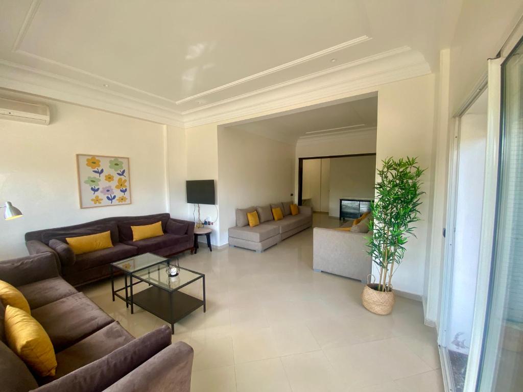 Appartement Vue Panoramique sur la siesta plage WELCOME STAY في المحمدية: غرفة معيشة كبيرة مع أرائك وطاولة