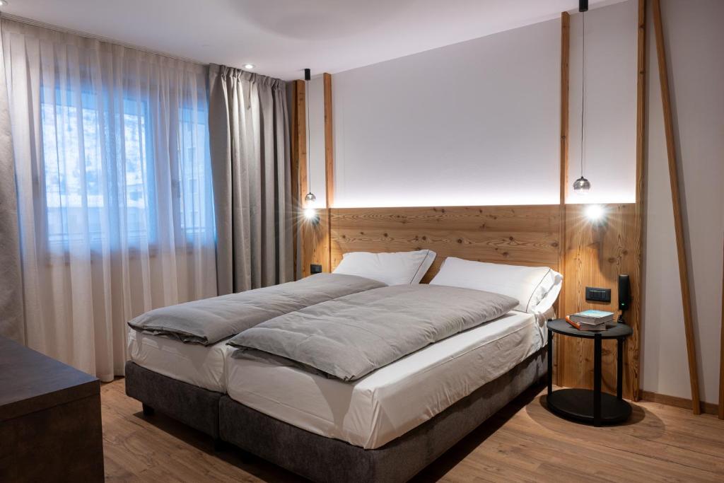 ein Schlafzimmer mit einem großen Bett und einem großen Fenster in der Unterkunft Le Sort Mountain Retreat in Passo del Tonale