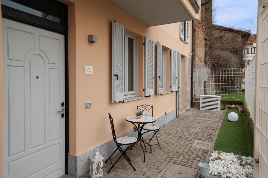 a patio with chairs and a table next to a building at Casa Laura - Home and Relax Malpensa in Lonate Pozzolo