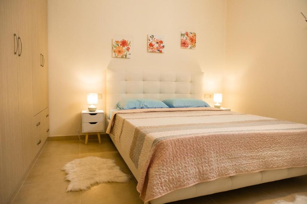 a bedroom with a large bed with two lamps at Eukalyptos 3BD apartment with yard in Chersonisos in Hersonissos