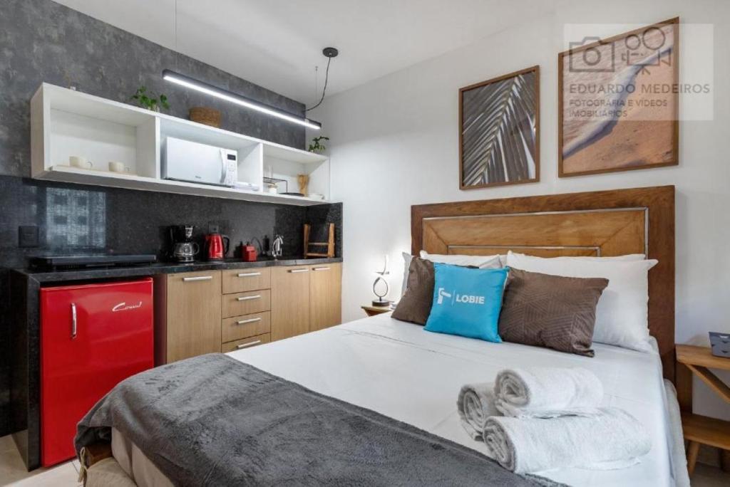 ein Schlafzimmer mit einem großen Bett und einem roten Kühlschrank in der Unterkunft Studio Centro - 7 Copas in Rio de Janeiro