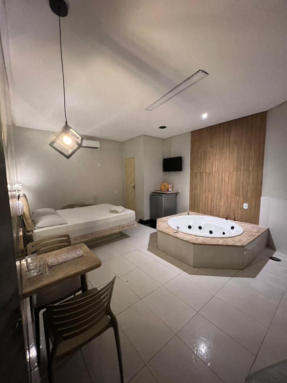 a large bathroom with a tub and a bed at Eros Motel in Natal