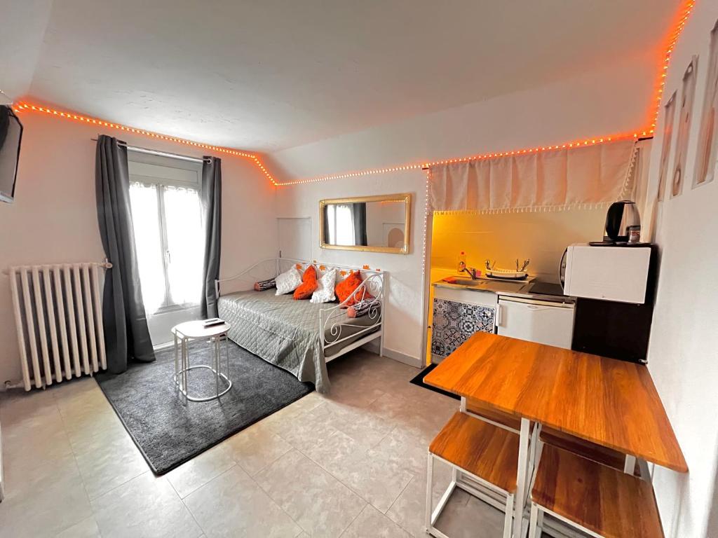 a small room with a bed and a kitchen at Atypique, calme & cosy, proche de Paris in Bonneuil-sur-Marne